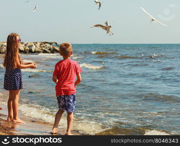 Kids playing outdoor on beach.. Joyful active childhood. Playful kids playing near water on seaside. Children having fun on summer beach. Young tourists spending actively time.