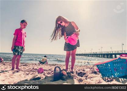 Kids playing outdoor on beach.. Joyful active childhood. Playful kids playing near water on seaside. Children having fun on summer beach. Young tourists spending actively time.