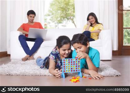 Kids playing while parents sit on sofa