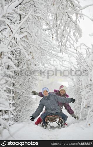 kids sit on sled in winter time