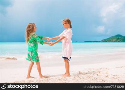 Kids together on the beach. Little girls having fun enjoying vacation on tropical beach