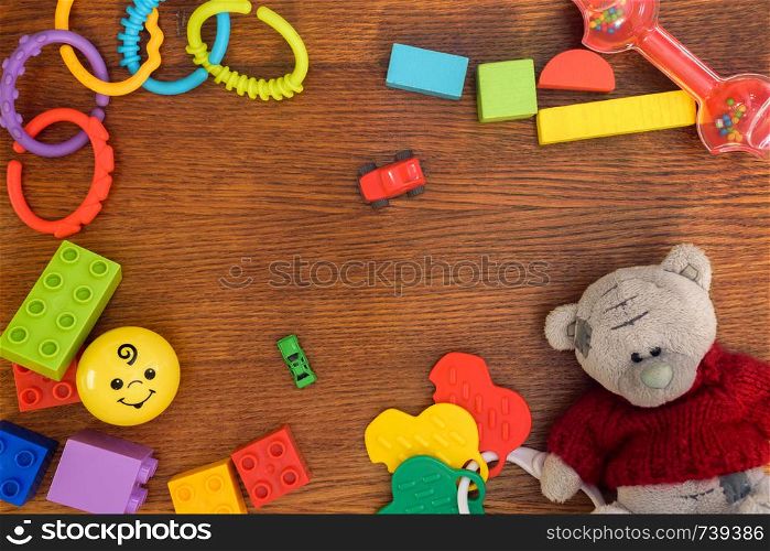 Kids toys background. Colorful toys, Bear, construction blocks and cubes on wooden table. Top view. Flat lay.. Kids toys background. Colorful toys, Bear,construction blocks and cubes on wooden table. Top view.
