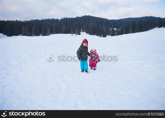 kids walking on snow at winter vacation in forest. happy children group have fun outdoor
