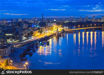 Kiev - Capital of Ukraine. View of the Dnieper River and the historic district of Podil. Night panorama of Kyiv.