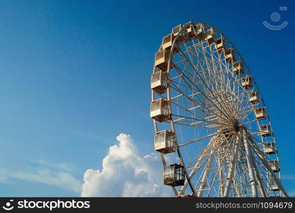 Kiev observation wheel against a beautiful bright blue sky with fluffy clouds, at sunset