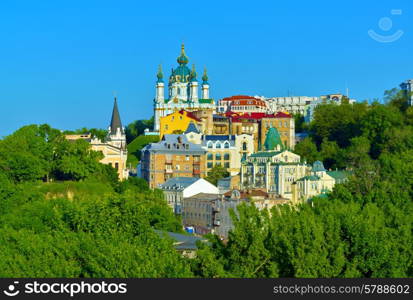 Kiev, Ukraine. Beautiful view of the ancient street Andrew&#39;s Descent and the St. Andrew&#39;s Church among green trees of the Castle Hill in Kyiv