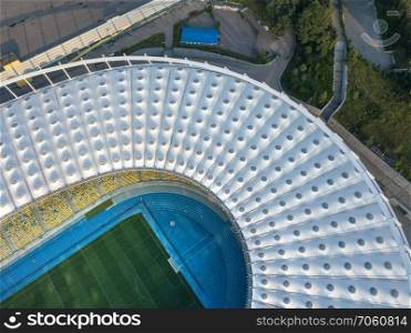 KIEV, UKRAINE - July 19, 2018. Aerial view from drone of the National Sports Complex Olimpiysky at summer sunset. Stadium cover structure with fields, tribunes and area around of the stadium.. KYIV, UKRAINE - July 19, 2018. Panoramic view from drone of construction the stadium roof, green football field, tribunes of National Sports Complex Olympic.