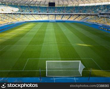 KIEV, UKRAINE - July 19, 2018: Aerial view from the drone Football gates at the green stadium with the yellow-blue stands of the Olympic National Sports Complex.. KIEV, UKRAINE - July 19, 2018: Panoramic view of a green field with blue-yellow stands and a football goal of the Olympic National Sports Complex
