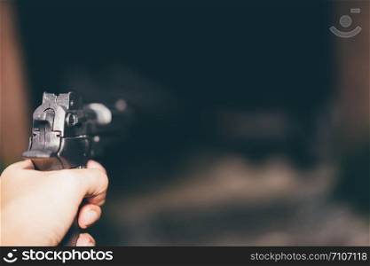 Killer with gun, a gun ready to shoot, aiming at the target, Focus on weapon