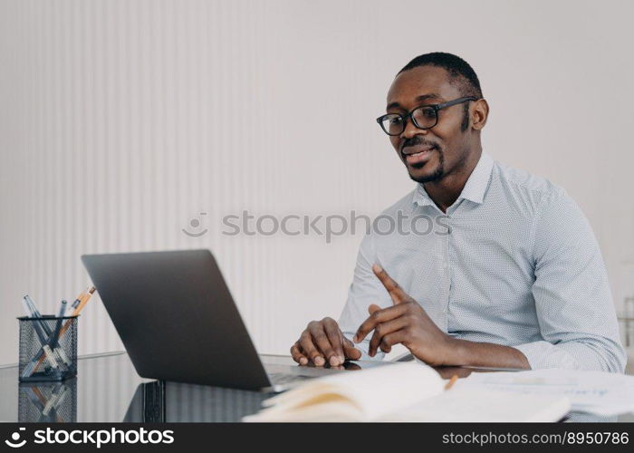 Kind boss, businessman in formal wear has online meeting in zoom. African american man is speaking in front of camera. Distant work at home concept. Remote conference or lesson.. Kind boss, businessman in formal wear has online meeting in zoom. African man in front of camera.