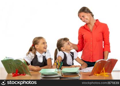 Kind teacher communicates with students sitting at a desk
