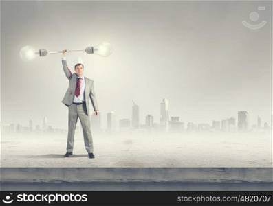 King of creativity. Young businessman in paper crown lifting barbell above head