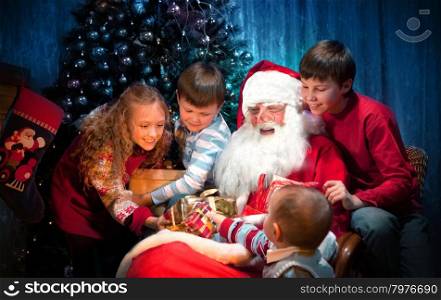 King Santa Clause giving Christmas Presents to Happy Children in the Christmas Night