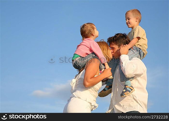 kissing parents with children on shoulders