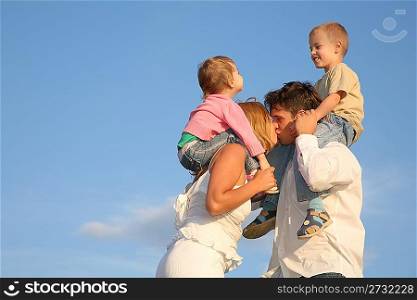 kissing parents with children on shoulders
