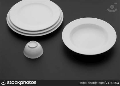 kitchen and restaurant utensils, plates, on a dark background. kitchen and restaurant utensils, dishes