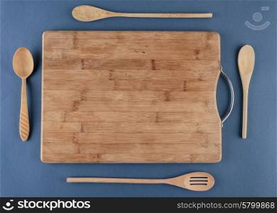 kitchen cutting board and a wooden spoon on a blue background