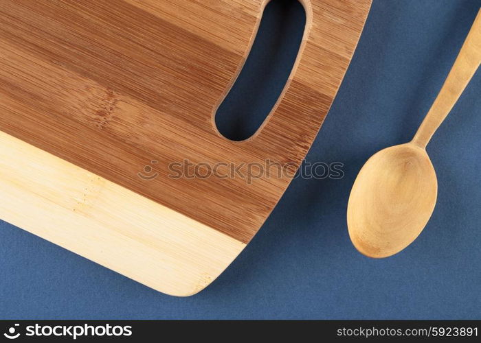 kitchen cutting board and a wooden spoon on a blue background