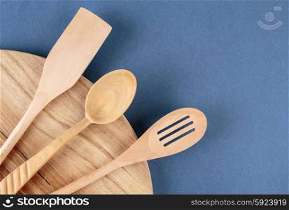 kitchen cutting board and a wooden spoon on a blue background