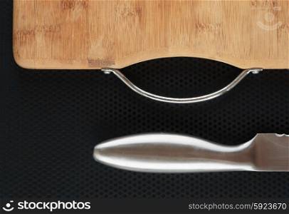 Kitchen cutting board and knife on a metal table