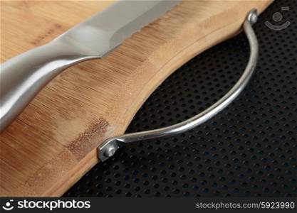 Kitchen cutting board and knife on a metal table