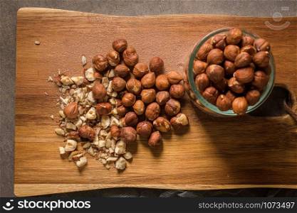 Kitchen cutting board with hazelnuts without shell, view from above.