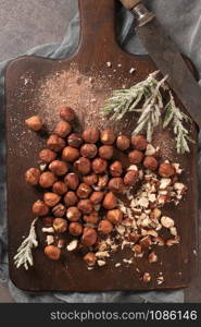 Kitchen cutting board with hazelnuts without shell, view from above.