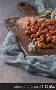 Kitchen cutting board with hazelnuts without shell, view from above.