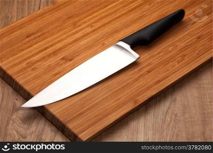 Kitchen knife on wood background