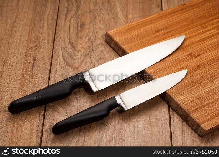 Kitchen knives on wood background