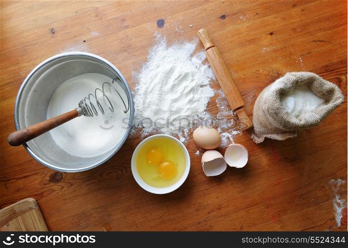 Kitchen rolling pin, eggs and flour on wooden background