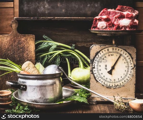 Kitchen table with cooking pot, ladle, vegetables and old weigher with raw meat , preparation of soup , broth or stew, front view. Country style