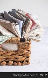 kitchen textile. stack of fabrics in different colors and textures, close-up. Kitchen towels on white background. Many fabric kitchen napkins in a wicker basket. Props for food photography