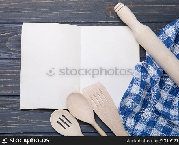 Kitchen utensil and notepad over wooden table background