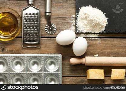 Kitchen utensils and ingredients for homemade pasta ravioli on wooden table