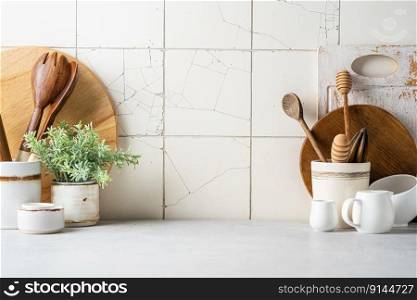 Kitchen utensils background with a blank space for a text and white tile background, home kitchen decor concept with kitchen tools, front view. Kitchen utensils background