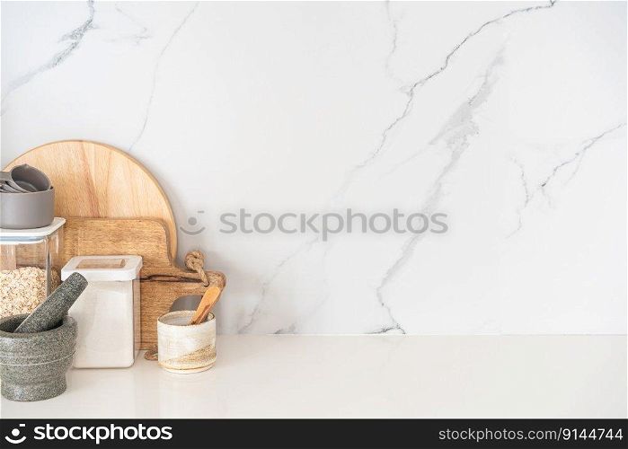 Kitchen utensils background with a blank space for a text and white marble background, home kitchen decor concept with kitchen tools, front view. Kitchen utensils background