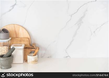 Kitchen utensils background with a blank space for a text and white marble background, home kitchen decor concept with kitchen tools, front view. Kitchen utensils background