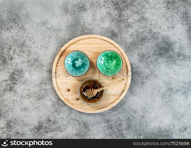 Kitchen utensils. Colorful plates and wooden board on stone background