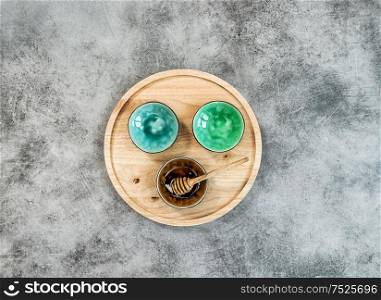 Kitchen utensils. Colorful plates and wooden board on stone background