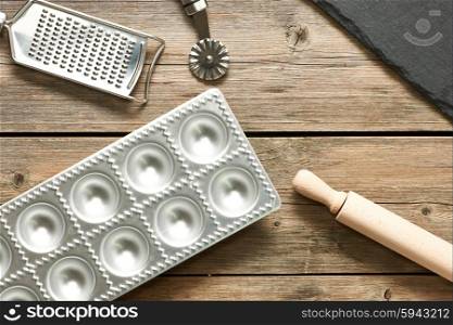 Kitchen utensils for homemade pasta ravioli on wooden table