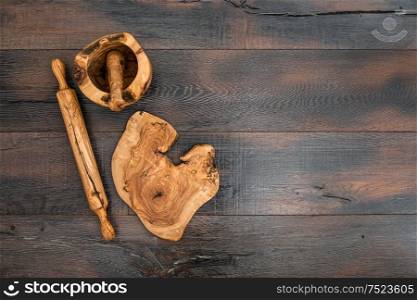 Kitchen utensils. Rolling pin, mortar and wooden board on rustic background