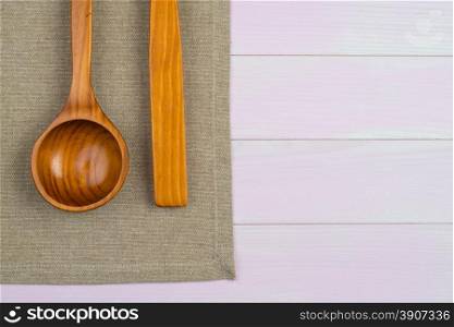 Kitchenware on beige towel over wooden kitchen table. View from above.