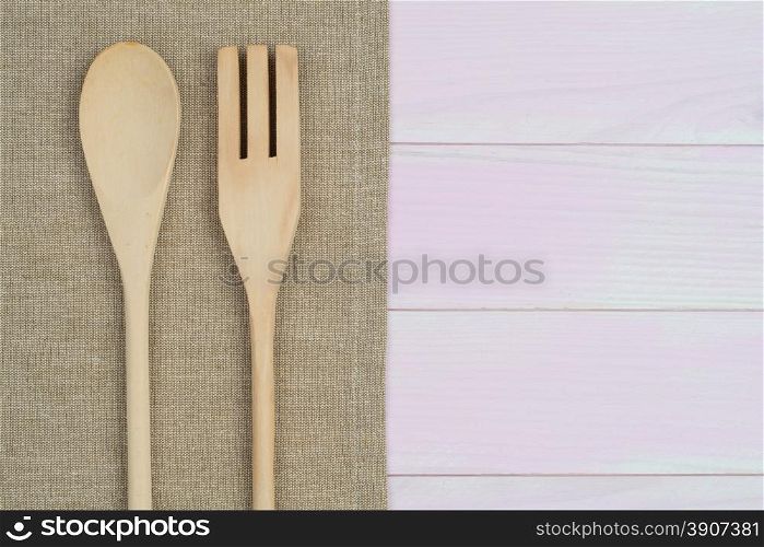 Kitchenware on beige towel over wooden kitchen table. View from above.