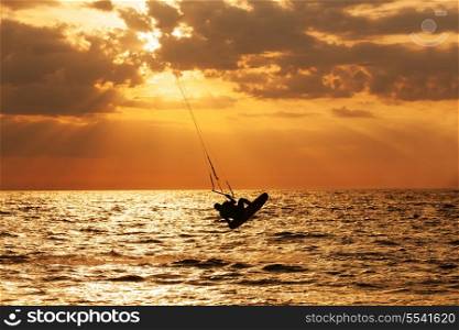 Kite surfer jumping from the water at sunset ocean&#xA;