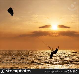 Kite surfer jumping from the water at sunset ocean&#xA;