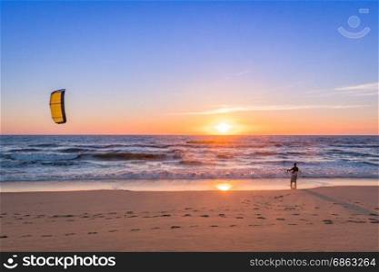 Kite surfer watching the waves at sunset in Portugal.