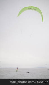 Kiteboarder with kite on the snow. Kite surfer being pulled by his kite across the snow