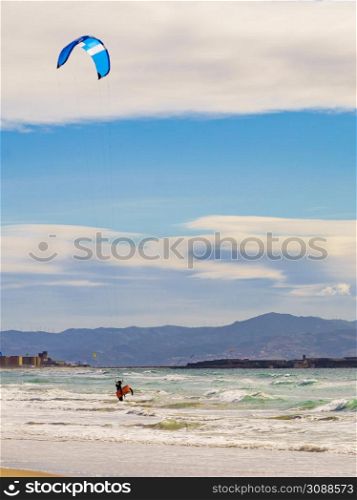 Kiteboarding. kite surfer rides the waves. Sports activity. Kitesurfing action.. Kite surfer riding waves. Kiteboarding sport.