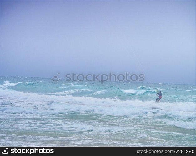 Kiteboarding. kite surfer rides the waves, Tarifa Spain. Sports activity. Kitesurfing action.. Kite surfer riding waves. Kiteboarding sport.